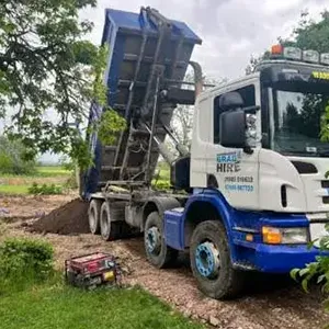 A dump truck parked on a dirt road.